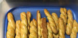 Χρυσαφένια κουλουράκια με άρωμα πορτοκαλιού, σερβιρισμένα σε πιατέλα.