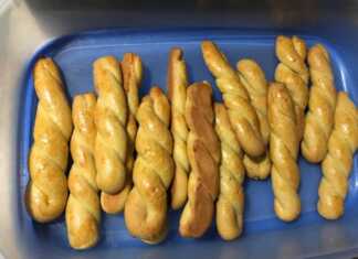 Χρυσαφένια κουλουράκια με άρωμα πορτοκαλιού, σερβιρισμένα σε πιατέλα.