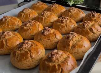 Αφράτα Κουλουράκια Πορτοκαλιού σε σχήμα μπάλας, με ένα καρύδι στην κορυφή, σερβιρισμένα σε πιατέλα.