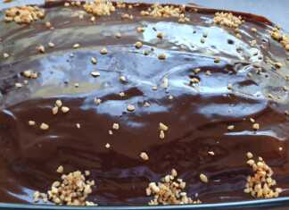 Σοκολατόπιτα, καλυμμένη με λαμπερό γλάσο σοκολάτας, κομμένη σε τετράγωνα κομμάτια.