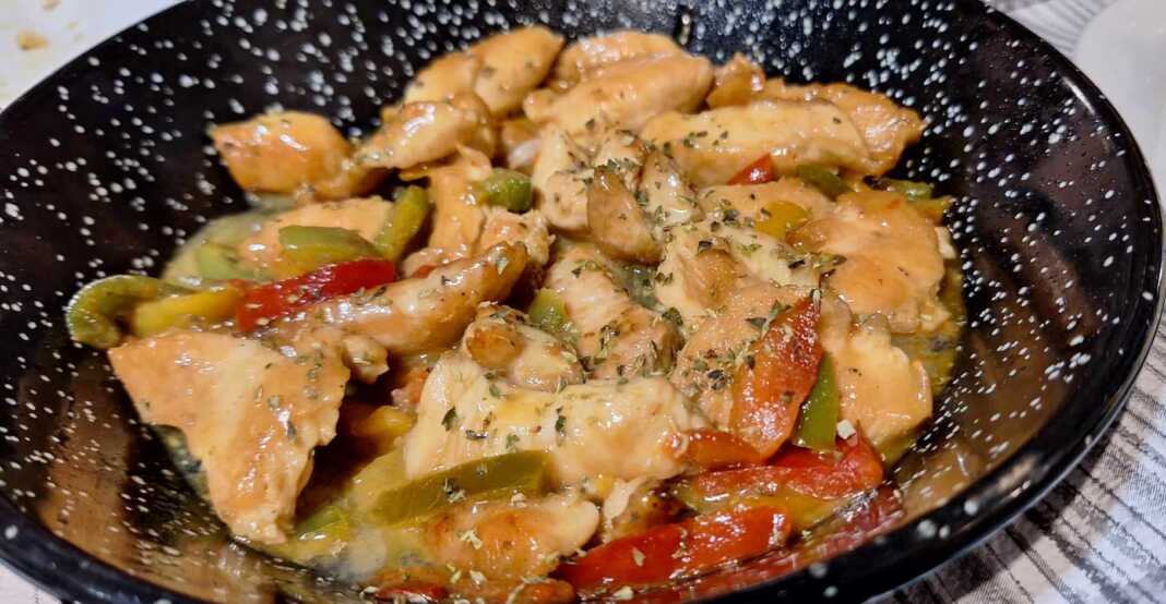 Ένα τηγάνι με κομμάτια κοτόπουλου σοταρισμένα μαζί με πράσινες, κόκκινες και μια καυτερή πιπεριά σε μια κόκκινη σάλτσα. Πασπαλισμένο με ρίγανη.