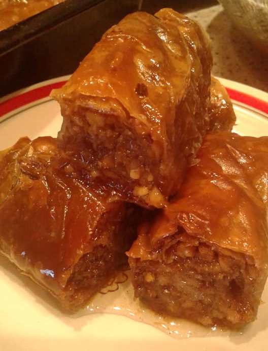 mpaklavadakiaGianiotika Κοντινό πλάνο σε ένα κομμάτι από Μπακλαβαδάκια Γιαννιώτικα Βουτυράτα, που φαίνεται η πλούσια γέμιση καρυδιού και τα τραγανά φύλλα.