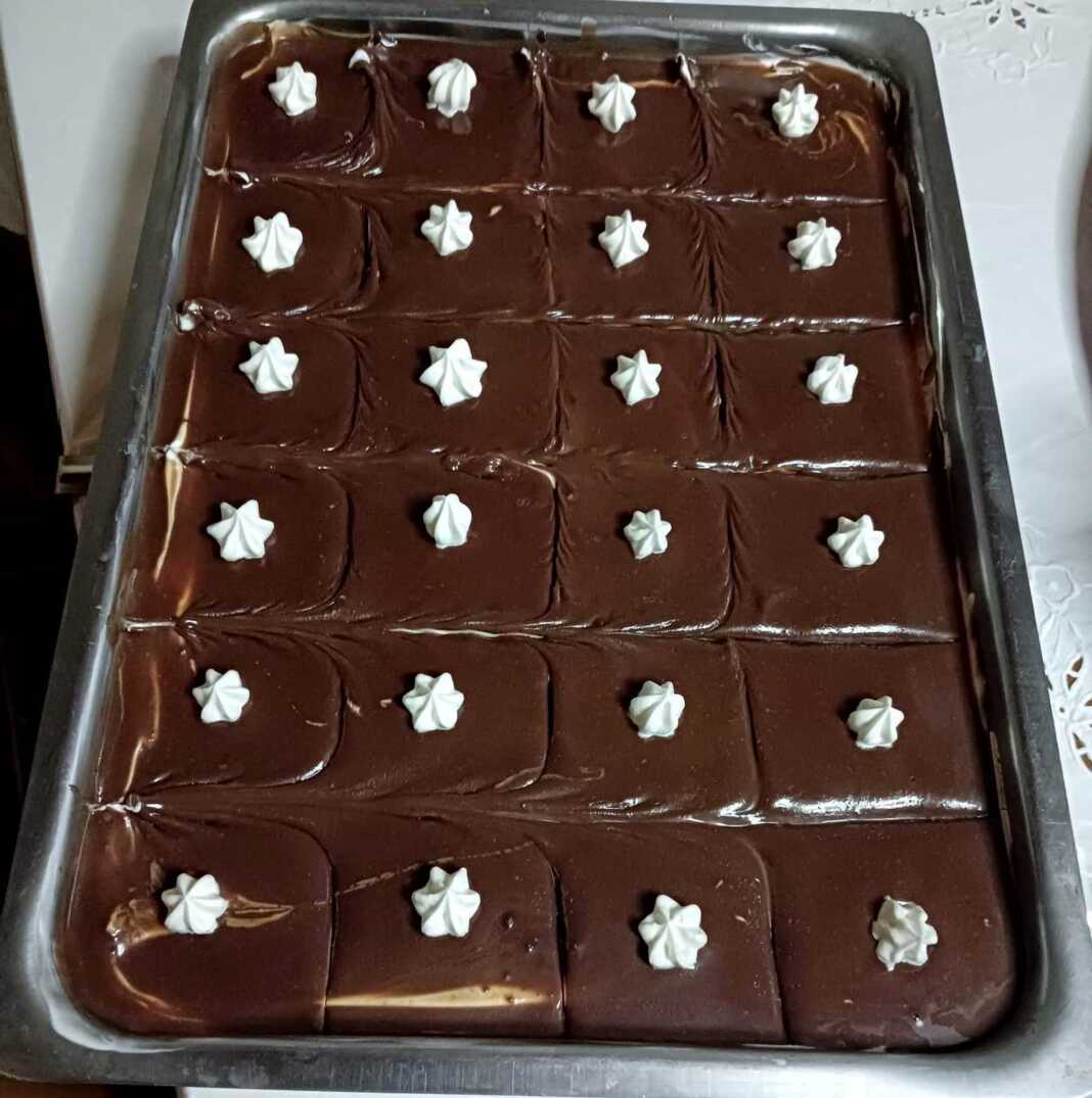 pastaTapsiou Ένα κομμάτι λαχταριστής πάστας ταψιού με στρώσεις μπισκότων και κρέμας σοκολάτας.