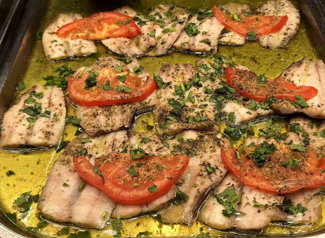 Σαρδέλες λεμονάτες στο φούρνο, φρεσκοψημένες σε ταψί, γαρνιρισμένες με μαϊντανό.