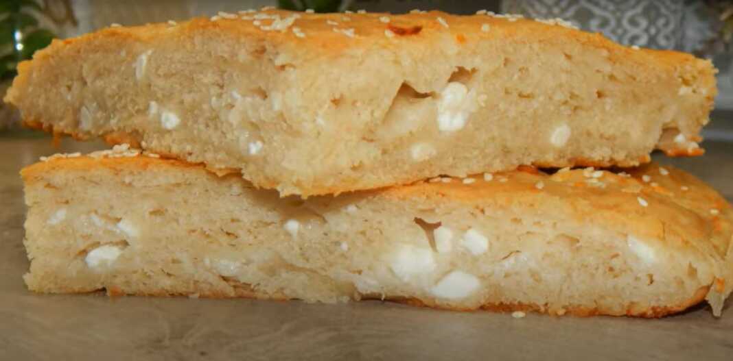 Αφράτη Τυρόπιτα χωρίς φύλλο, φρεσκοψημένη σε ταψί, με χρυσαφένια κρούστα και σουσάμι