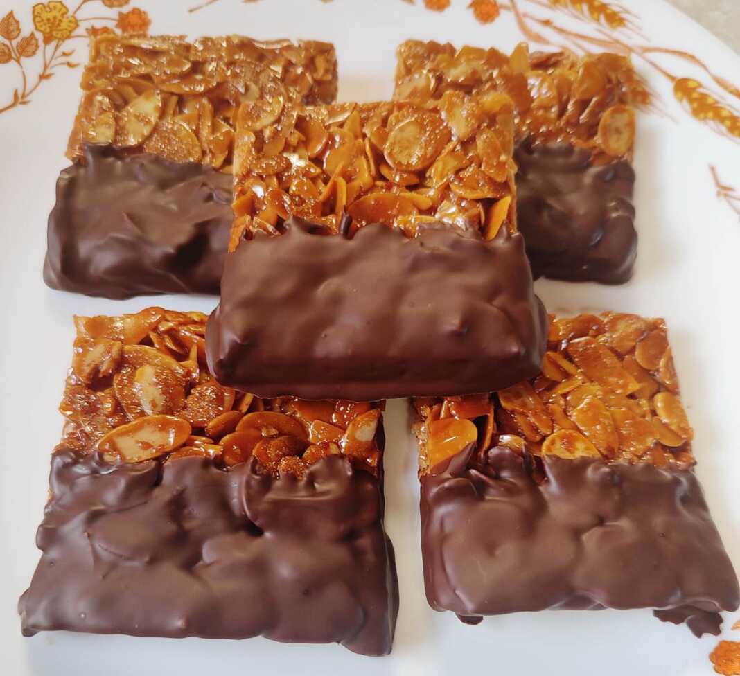 Εύκολη συνταγή για πεντανόστιμες, τραγανές φλωρεντίνες με καραμελωμένα αμύγδαλα και επικάλυψη σοκολάτας. Ιδανικό γλυκάκι για καφέ ή δώρο!