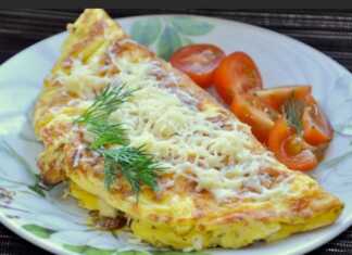 Μια πολύ φουσκωτή και χρυσαφένια ομελέτα σερβιρισμένη σε πιάτο με λιωμένο τυρί να ξεχωρίζει στο εσωτερικό της