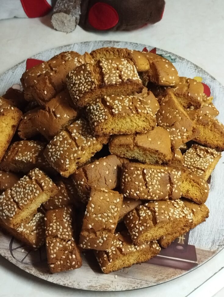 Πιατέλα γεμάτη με τραγανά παξιμαδάκια πορτοκαλιού πασπαλισμένα με σουσάμι