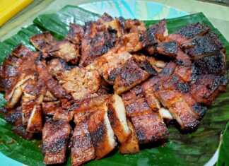 Φέτες χοιρινής πανσέτας με λαχταριστή γυαλιστερή καραμελωμένη κρούστα σερβιρισμένες σε ξύλινη επιφάνεια κομμένες σε μπουκιές