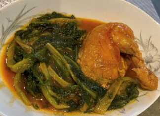 Πιάτο με κοτόπουλο με χόρτα, σε κόκκινη σάλτσα, γαρνιρισμένο με άνηθο.