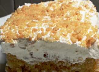 Μια εντυπωσιακή αμυγδαλότουρτα με λευκή σαντιγί, διακοσμημένη με καβουρδισμένα αμύγδαλα και πλούσια κρέμα