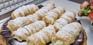 Πιάτο με χρυσαφένια, τραγανά κορνέ σφολιάτας, γεμιστά με λευκή σαντιγί και πασπαλισμένα με άχνη ζάχαρη.