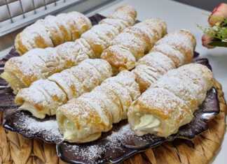 Πιάτο με χρυσαφένια, τραγανά κορνέ σφολιάτας, γεμιστά με λευκή σαντιγί και πασπαλισμένα με άχνη ζάχαρη.