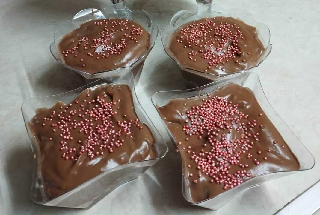 Ατομικά ποτήρια με στρώσεις κρέμας σοκολάτας και θρυμματισμένων μελομακάρονων, γαρνιρισμένα με καρύδι.