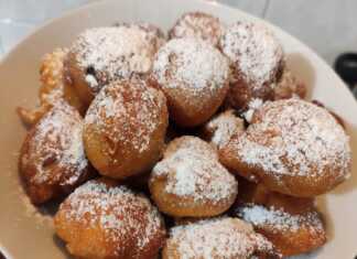 Μια πιατέλα με χρυσαφένιες αφράτες τηγανίτες πασπαλισμένες με ζάχαρη άχνη και διάσπαρτες σταφίδες στο εσωτερικό τους