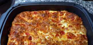 Η πίτα μέσα στη γάστρα, έτοιμη για ψήσιμο, με τα σουρωτά φύλλα και τα ντοματίνια