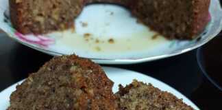 Δύο κομμάτια σιροπιαστή καρυδόπιτα, με ορατά τα καρύδια και τη μελωμένη υφή, σερβιρισμένο σε πιάτο.