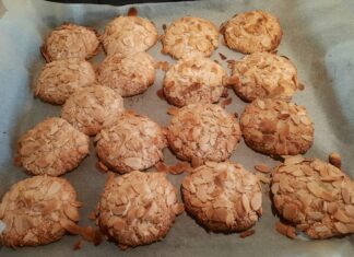 Ένα ταψί με φρεσκοψημένα αμυγδαλωτά, με φιλέ αμυγδάλου στην επιφάνεια.