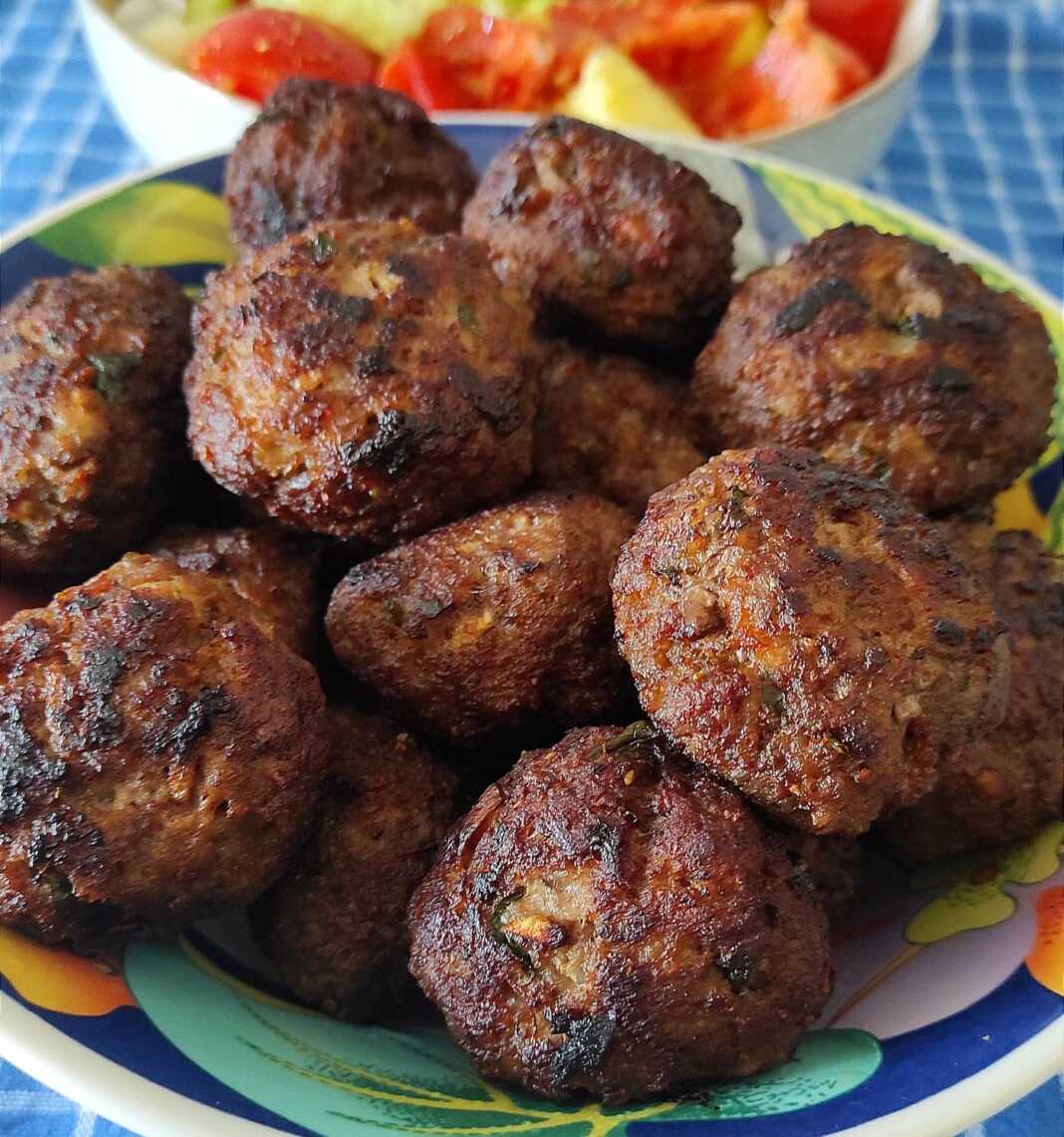 Χρυσαφένιοι κεφτέδες που τηγανίζονται σε ένα τηγάνι.