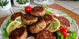 Ένα πιάτο με στρογγυλά, ροδοψημένα μπιφτέκια τόνου περιχυμένα με λευκή σάλτσα άνηθου και φρέσκο άνηθο.