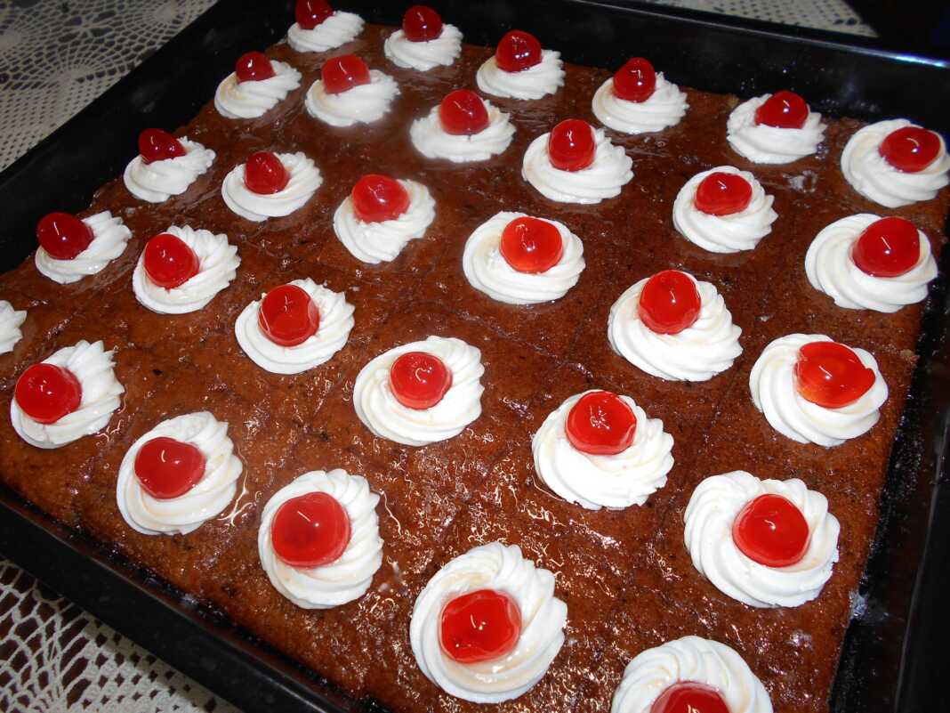 Ένα κομμάτι αφράτο Ρεβανί Βέροιας, πλούσια σιροπιασμένο, σερβιρισμένο σε πιάτο.