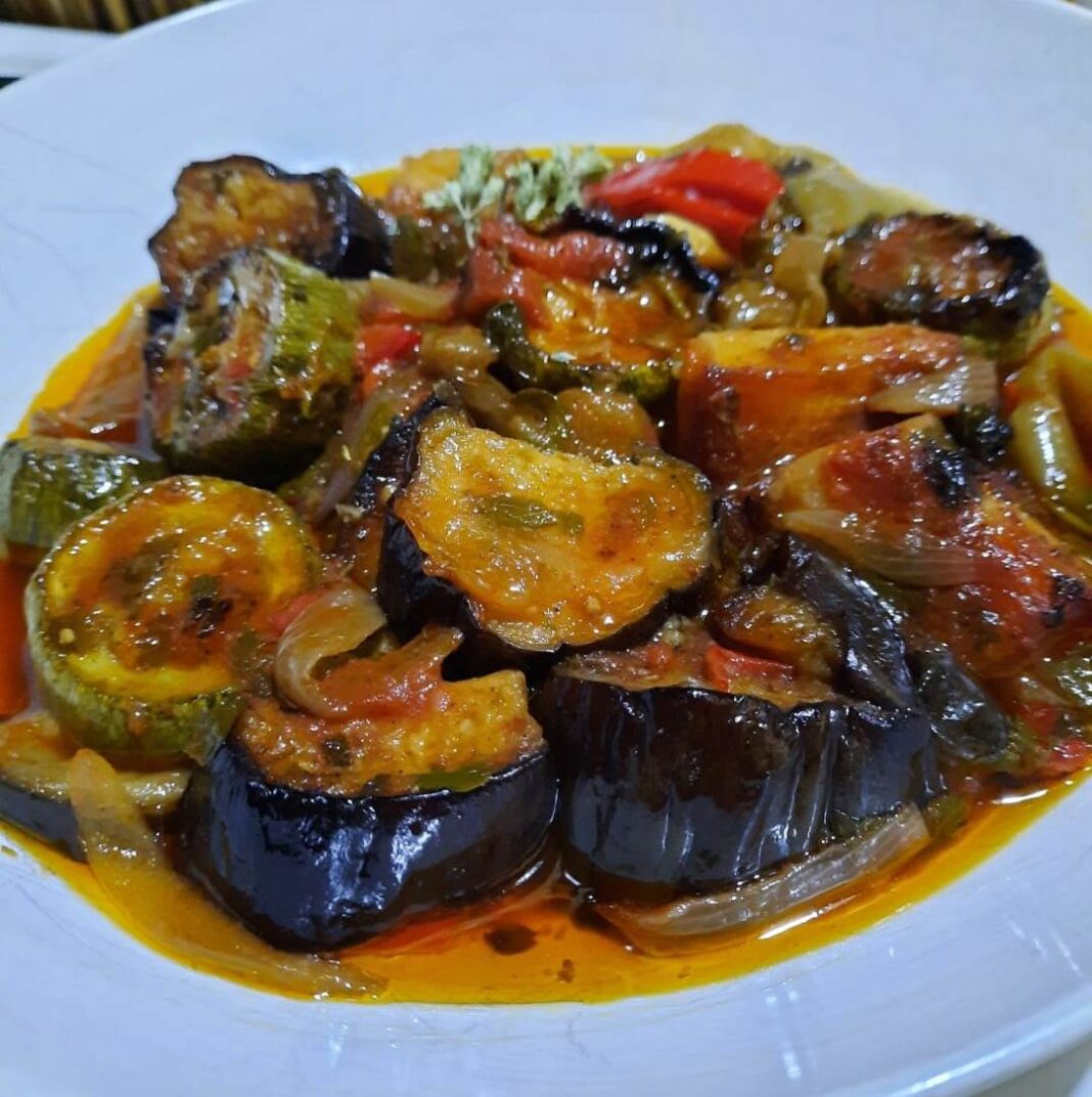 Ένα πιατο με ζεστό τουρλού γεμάτο πολύχρωμα λαχανικά σε σάλτσα ντομάτας.