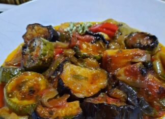 Ένα πιατο με ζεστό τουρλού γεμάτο πολύχρωμα λαχανικά σε σάλτσα ντομάτας.