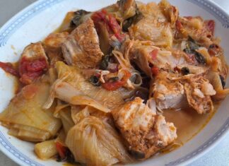 Πιάτο με χοιρινό πρασοσέλινο κοκκινιστό, γαρνιρισμένο με φρέσκο άνηθο και σάλτσα ντομάτας.