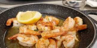 Για να τηγανίσετε τέλεια τις γαρίδες χωρίς κέλυφος, ακολουθήστε τις συμβουλές Ένα τηγάνι γεμάτο χρυσαφένιες, τηγανητές γαρίδες, μερικές από τις οποίες είναι κομμένες και δείχνουν την εσωτερική τους σάρκα.