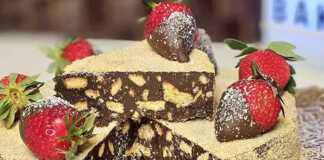 Τούρτα Μωσαϊκό Όνειρο διακοσμημένη με τριμμένο μπισκότο και φράουλες, σερβιρισμένη σε πιατέλα.