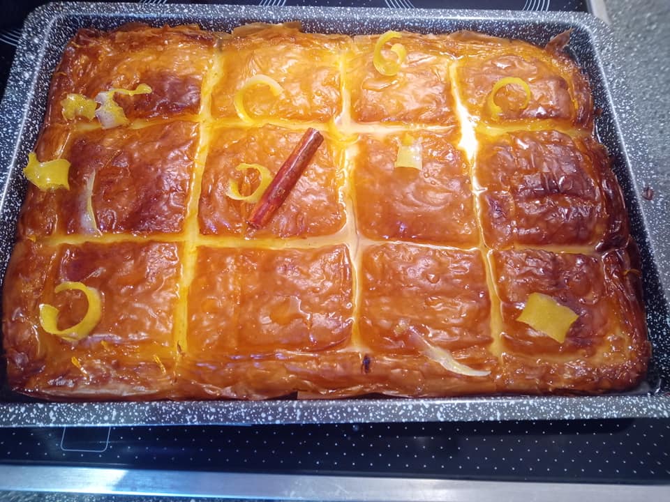 galaktoboureko Χρυσαφένιο ταψί με γαλακτομπούρεκο κομμένο σε κομμάτια που αστράφτουν από το σιρόπι και πλούσια κρέμα να ξεπροβάλλει