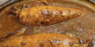 Προετοιμασία γεμιστών καλαμαριών σε ταψί, πριν το ψήσιμο, με πλούσια σάλτσα.