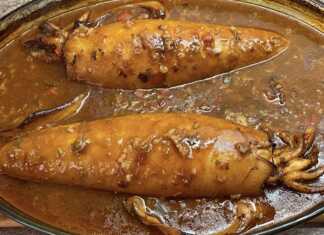 Προετοιμασία γεμιστών καλαμαριών σε ταψί, πριν το ψήσιμο, με πλούσια σάλτσα.