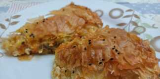 Μια χρυσαφένια μανιταρόπιτα σε ταψί, με ορατά τα τραγανά φύλλα κρούστας και τη λαχταριστή γέμιση.