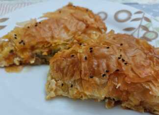 Μια χρυσαφένια μανιταρόπιτα σε ταψί, με ορατά τα τραγανά φύλλα κρούστας και τη λαχταριστή γέμιση.