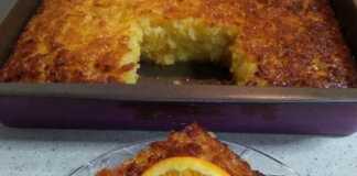 Πορτοκαλόπιτα σιροπιασμένη, κομμένη σε τετράγωνα κομμάτια, με φλούδες πορτοκαλιού για διακόσμηση.