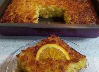 Πορτοκαλόπιτα σιροπιασμένη, κομμένη σε τετράγωνα κομμάτια, με φλούδες πορτοκαλιού για διακόσμηση.