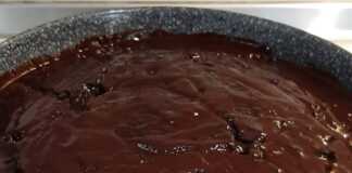 Ένα κομμάτι νηστίσιμη σοκολατόπιτα με σκούρο γλάσο σοκολάτας στην κορυφή, σερβιρισμένο σε πιάτο.