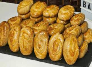 Ταψί με καλοσχηματισμένα χρυσαφένια πασχαλινά κουλουράκια βανίλιας, γυαλιστερά από το άλειμμα αυγού