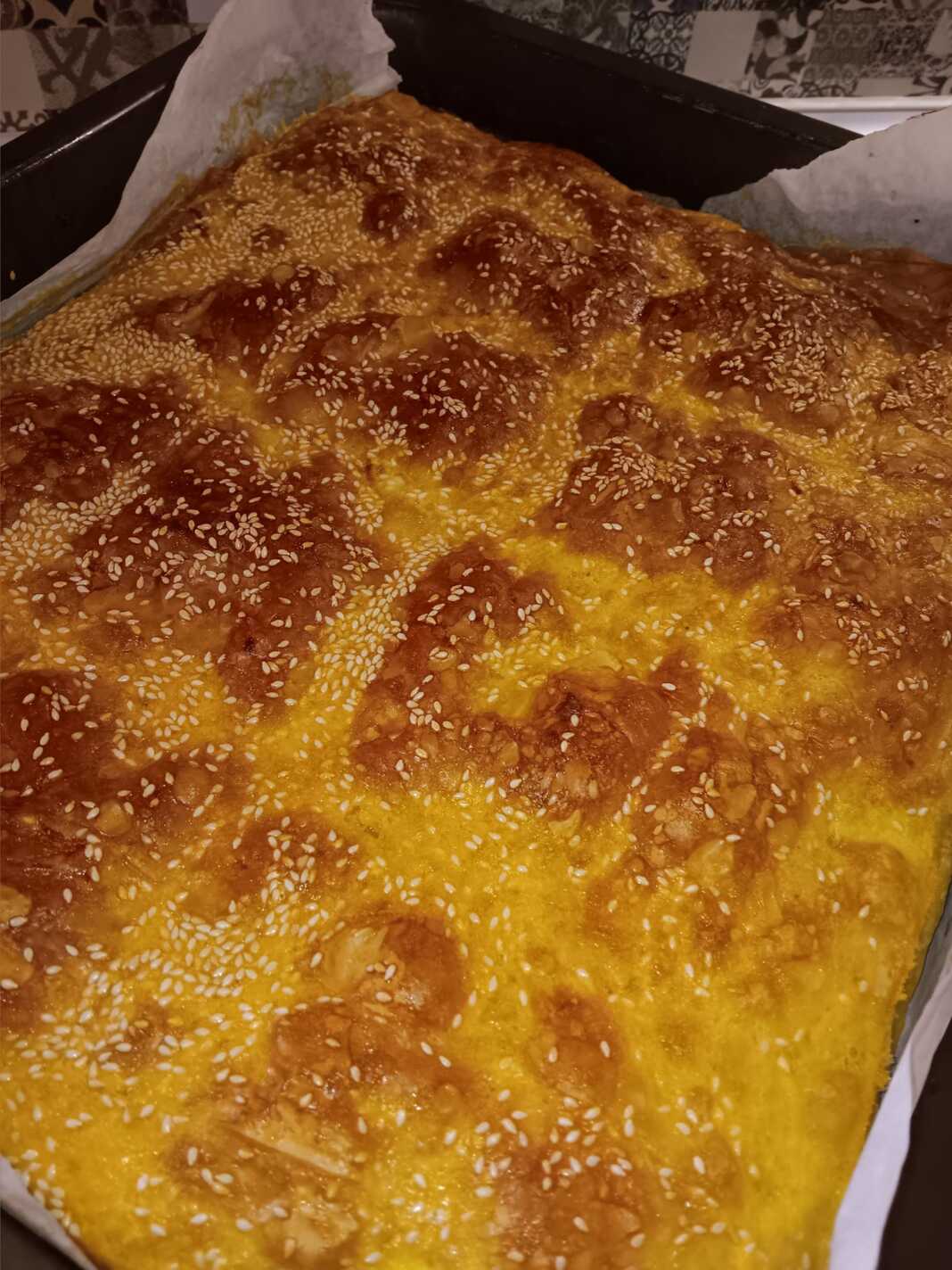 Τραγανή χρυσαφένια τυρόπιτα με Ζαγορίσιο φύλλο κομμένη σε κομμάτια, έτοιμη για σερβίρισμα.