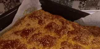 Τραγανή χρυσαφένια τυρόπιτα με Ζαγορίσιο φύλλο κομμένη σε κομμάτια, έτοιμη για σερβίρισμα.