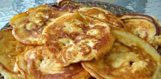 Αφράτες, χρυσαφένιες τηγανόπιτες της γιαγιάς σε ένα πιάτο, περιχυμένες με μέλι.