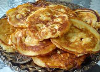 Αφράτες, χρυσαφένιες τηγανόπιτες της γιαγιάς σε ένα πιάτο, περιχυμένες με μέλι.