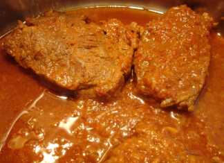 Ένα λαχταριστό πιάτο χοιρινό κατσαρόλας με σάλτσα ντομάτας σερβιρισμένο σε πιάτο.