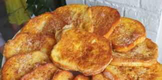 Ζεστές αυγοφέτες πασπαλισμένες με ζάχαρη και κανέλα σε ένα πιάτο.