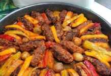 Ένα ταψί με ψημένα μπιφτέκια σε σειρά, εναλλάξ με φέτες από πατάτες, πιπεριές, κρεμμύδια και ντομάτες, όλα με ωραίο χρυσαφένιο χρώμα.