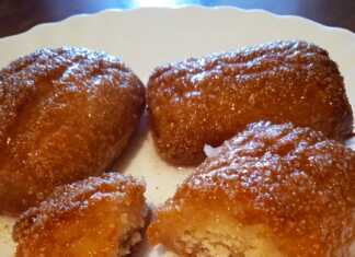 Μια πιατέλα με σιροπιαστά, στρογγυλά μπισκότα καρύδας, πασπαλισμένα με τριμμένη καρύδα.