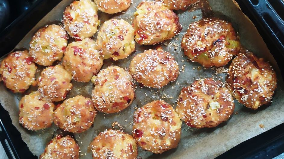 tirompalitses pitsas Οι ψημένες **Τυρομπαλίτσες Πίτσας** σε πιατέλα, πασπαλισμένες με σουσάμι