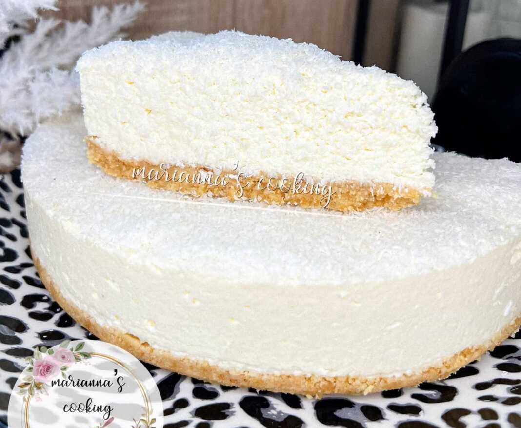 Λαχταριστό cheesecake καρύδας με λευκή κρέμα και τριμμένη καρύδα, σερβιρισμένο σε πιατέλα.