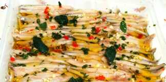 Πιάτο με φρεσκομαριναρισμένο γαύρο, γαρνιρισμένο με ψιλοκομμένο μαϊντανό, πιπεριά και φέτες λεμονιού.